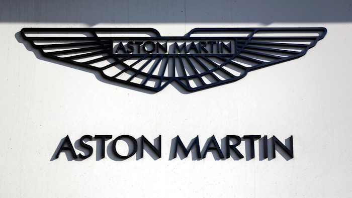 In this file photo dated Wednesday, Feb. 24, 2016, an Aston Martin sign is seen outside a dealership on Park Lane in London. Aston Martin Lagonda, the maker of James Bond's favorite sports car, said Thursday Sept. 20, 2018, that it plans to raise as much as 1.27 billion pounds (dlrs 1.67 billion US) when it sells shares to investors for the first time.