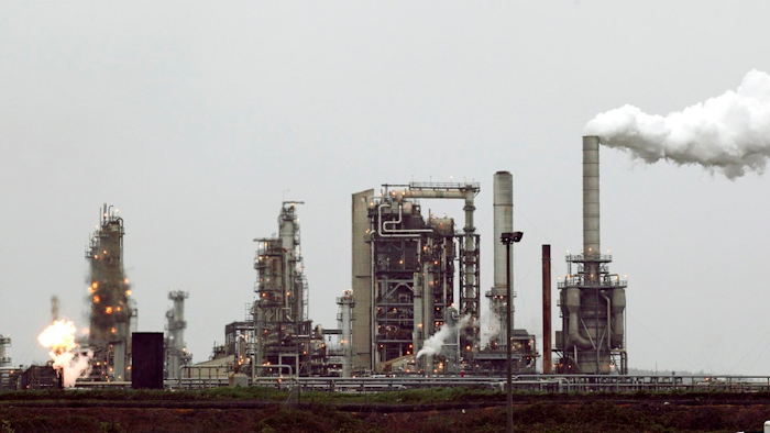 This April 2, 2010 file photo shows a refinery owned by Andeavor, formerly Tesoro Corp. including a gas flare flame that is part of normal plant operations, in Anacortes, Wash. A campaign bankrolled by the oil industry has raised $20.46 million to defeat a carbon pollution fee on the ballot in Washington state aiming at tackling climate change.