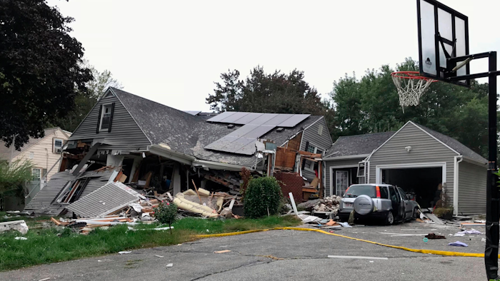 A collapsed home and car sit damaged on Chickering Street in Lawrence, MA after a series of gas explosions in several communities north of Boston. Authorities said Leonel Rondon died after the chimney toppled by the exploding house crashed into his car in the driveway.