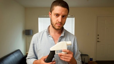 In this May 10, 2013, file photo, Cody Wilson, the founder of Defense Distributed, shows a plastic handgun made on a 3D-printer at his home in Austin, Texas.