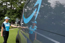 In this June 27, 2018, file photo, Parisa Sadrzadeh, a senior manager of logistics for Amazon.com, opens the door of an Amazon-branded delivery van at the request of a photographer in Seattle, following a media event for Amazon to announce a new program that lets entrepreneurs around the country launch businesses that deliver Amazon packages. Amazon says it has ordered 20,000 vans for its new delivery program. The online retailer says “tens of thousands” of individuals have applied for the program, and it had to up its van order to 20,000 from 4,500.