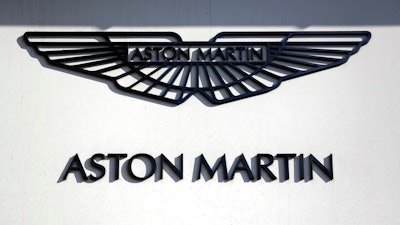 In this file photo dated Wednesday, Feb. 24, 2016, an Aston Martin sign is seen outside a dealership on Park Lane in London. Aston Martin Lagonda, the maker of James Bond's favorite sports car, said Thursday Sept. 20, 2018, that it plans to raise as much as 1.27 billion pounds (dlrs 1.67 billion US) when it sells shares to investors for the first time.