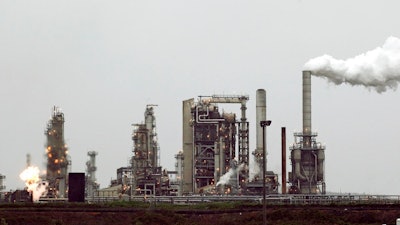 This April 2, 2010 file photo shows a refinery owned by Andeavor, formerly Tesoro Corp. including a gas flare flame that is part of normal plant operations, in Anacortes, Wash. A campaign bankrolled by the oil industry has raised $20.46 million to defeat a carbon pollution fee on the ballot in Washington state aiming at tackling climate change.