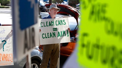 Paul Gipe protests before the first of three public hearings on the Trump administration's proposal to roll back car-mileage standards in a region with some of the nation's worst air pollution Monday, Sept. 24, 2018 in Fresno, Calif. The day-long session by the U.S. Environmental Protection Agency and National Highway Traffic Safety Administration is a means to gather public comment concerning the mileage plan, which would freeze U.S. mileage standards at levels mandated by the Obama administration for 2020, instead of letting them rise to 36 miles per gallon by 2025.
