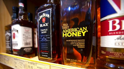 In this July 7, 2018, file photo, whiskeys distilled and bottled in the U.S. are displayed for sale in a grocery store in Beijing. Kentucky's bourbon distilleries turned up the pace of production again last year, boosting overall inventory to 7.5 million barrels of aging whiskey, the highest volume since 1972.