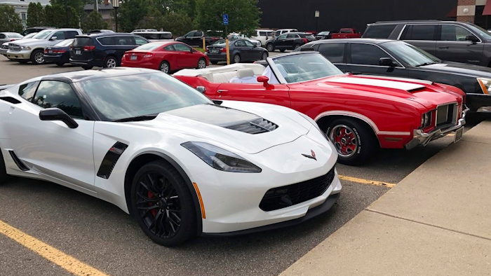 In this Aug. 18, 2018 photo, a Corvette Z06 is seen parked next to an Oldsmobile Cutlass in Birmingham, Mich. Muscle car fans consider the Ford Mustang, Chevrolet Camaro and Corvette and the Dodge Challenger and Charger to be the mainstays of Detroit performance cars. But their combined sales fell 7 percent in 2016, 11 percent last year, and are down almost 10 percent for the first half of 2018, according to numbers provided by Kelley Blue Book.