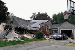 A collapsed home and car sit damaged on Chickering Street in Lawrence, MA after a series of gas explosions in several communities north of Boston. Authorities said Leonel Rondon died after the chimney toppled by the exploding house crashed into his car in the driveway.