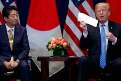 President Donald Trump takes a letter from North Korean leader Kim Jong-un from his suit coat pocket during a meeting with Japanese Prime Minister Shinzo Abe at the Lotte New York Palace hotel during the United Nations General Assembly, Wednesday, Sept. 26, 2018, in New York.