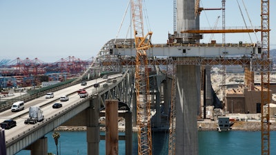 In this July 2, 2018, photo, traffic moves on the old Gerald Desmond Bridge next to its replacement bridge under construction in Long Beach, Calif. The new Gerald Desmond Bridge at the nation’s second-busiest port isn’t just a crucial route for cargo trucks and Southern California commuters - it’s a concrete-and-steel science experiment for engineers and seismologists. It’s slated to open next year.