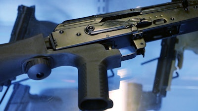 This Oct. 4, 2017 file photo shows a device called a 'bump stock' attached to a semi-automatic rifle at a gun store and shooting range in Utah. What's happened to bump stocks in the year since Las Vegas? There were growing calls to ban the devices in the immediate aftermath of the mass shooting on the Las Vegas strip. Some succeeded, but others did not.