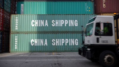 In this July, 5, 2018, file photo, a jockey truck passes a stack of 40-foot China Shipping containers at the Port of Savannah in Savannah, Ga. The path to peace in a trade war between the United States and China is getting harder to find as the world's two biggest economies pile ever more taxes on each other's products.