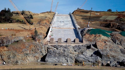 In this Nov. 30, 2017, file photo, work continues on the Oroville Dam spillway in Oroville, Calif. Officials say the cost of dealing with last year's near-disaster at the nation's tallest dam in California have climbed to more than $1 billion. The state Department of Water Resources said Wednesday, Sept. 5, 2018, construction costs and related expenses are driving the increase at Oroville Dam.