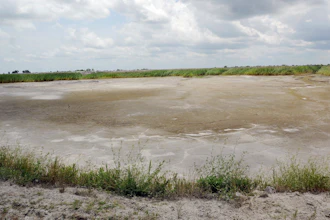 In this June 23, 2014 file photo, the dried-up bed of an inactive coal ash pond is seen at Duke Energy's Sutton plant in Wilmington, N.C. Duke Energy says heavy rains from Florence have caused a slope to collapse at a coal ash landfill at a closed power station near the North Carolina coast. Duke spokeswoman Paige Sheehan said Saturday night, Sept. 15, 2018, that about 2,000 cubic yards of ash have been displaced at the L. V. Sutton Power Station outside Wilmington.