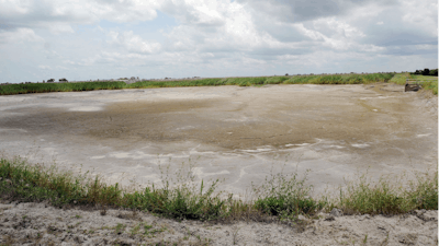 In this June 23, 2014 file photo, the dried-up bed of an inactive coal ash pond is seen at Duke Energy's Sutton plant in Wilmington, N.C. Duke Energy says heavy rains from Florence have caused a slope to collapse at a coal ash landfill at a closed power station near the North Carolina coast. Duke spokeswoman Paige Sheehan said Saturday night, Sept. 15, 2018, that about 2,000 cubic yards of ash have been displaced at the L. V. Sutton Power Station outside Wilmington.