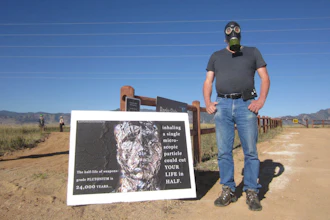 Stephen Parlato wears a gas mask next to his sign warning about the dangers of plutonium at Rocky Flats National Wildlife Refuge outside Denver on Saturday, Sept. 15, 2018, the first day the refuge was open to the public. The refuge is on the outskirts of a former U.S. government factory that manufactured plutonium triggers for nuclear weapons.