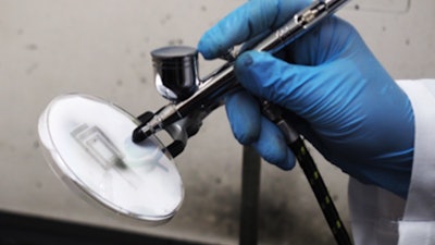 Spraying an antenna onto a flat surface.