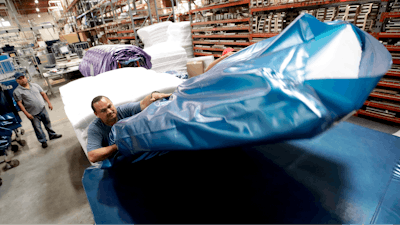 In this July 5, 2018, photo workers assemble the Afloat water mattresses at the factory in Corona, Calif. On Thursday, Sept. 27, the Commerce Department releases its August report on durable goods.