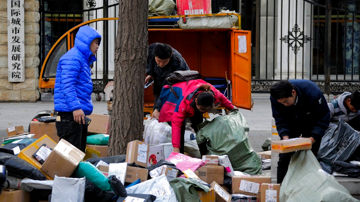 In this Tuesday, Oct. 30, 2018, photo, delivery workers sort boxes of goods for their customers outside the capital city development academy in Beijing. An official measure of China's manufacturing activity fell to a two-year low in October, adding to pressure on Beijing to shore up economic growth amid a tariff war with Washington. The monthly purchasing managers' index issued Tuesday by the National Bureau of Statistics and an industry group, the China of Logistics and Purchasing, fell to 50.2 from September's 50.8 on a 100-point scale.