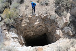 This Sept. 7, 2018, photo shows Nick Castleton looking down a shaft, near Eureka, Utah. Underneath the landscape of the U.S. West lie hundreds of thousands of abandoned mines, an underground world that can hold serious danger and unexpected wonder.