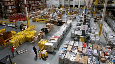 n this Aug. 3, 2017, file photo, workers prepare to move products at an Amazon fulfillment center in Baltimore. Amazon’s announcement Tuesday, Oct. 2, 2018, that it will raise its minimum wage to $15 an hour will intensify the pressure on other companies to also lift their pay levels, particularly retailers and warehouse operators that are looking to staff up for the holidays.