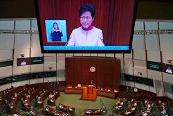 A video screen shows Hong Kong Chief Executive Carrie Lam delivering her policy speech at the Legislative Council in Hong Kong Wednesday, Oct. 10, 2018. Lam has unveiled a major reclamation project called 'Lantau Tomorrow Vision,' under which about 1,700 hectares will be developed to provide homes for 1.1 million people, according to government radio.