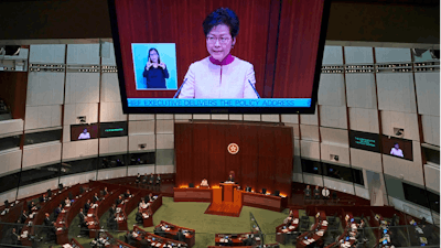 A video screen shows Hong Kong Chief Executive Carrie Lam delivering her policy speech at the Legislative Council in Hong Kong Wednesday, Oct. 10, 2018. Lam has unveiled a major reclamation project called 'Lantau Tomorrow Vision,' under which about 1,700 hectares will be developed to provide homes for 1.1 million people, according to government radio.