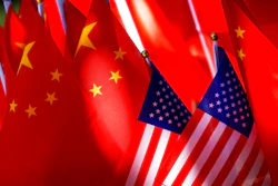 In this Sept. 16, 2018, file photo, American flags are displayed together with Chinese flags on top of a trishaw in Beijing. China on Thursday, Oct. 18, 2018 criticized Washington’s decision to leave the United Nations treaty that regulates international postage that comes amid a worsening trade dispute between the world’s top two economies.