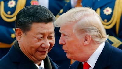 In this Nov. 9, 2017, file photo, U.S. President Donald Trump, right, chats with Chinese President Xi Jinping during a welcome ceremony at the Great Hall of the People in Beijing. The White House’s move to expand Washington’s dispute with Beijing beyond trade and technology and into accusations of political meddling have sunk relations between the world’s two largest economies to their lowest level since the end of the Cold War.