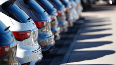 In this Oct. 21, 2018, photo a long line of unsold 2018 QX60 sports utility vehicles cast long shadows at an Infiniti dealership in Highlands Ranch, Colo. On Monday, Oct. 29, the Commerce Department issues its September report on consumer spending, which accounts for roughly 70 percent of U.S. economic activity.