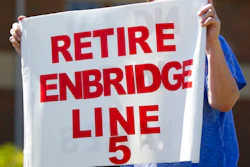 In this July 6, 2017, file photo, Lauren Sargent, takes part in a protest before the Enbridge Line 5 pipeline public information session in Holt, Mich. Officials tell The Associated Press that Michigan Gov. Rick Snyder's administration and Canadian pipeline giant Enbridge have reached a deal on replacing 65-year-old twin pipelines in a channel linking two of the Great Lakes. An announcement was scheduled for Wednesday Oct. 3, 2018. Officials tell the AP the agreement calls for shutting down the Line 5 pipes in the Straits of Mackinac connecting Lakes Huron and Michigan.