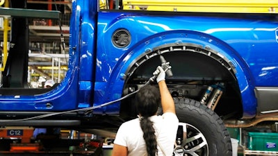 In this Sept. 27, 2018, file photo a United Auto Workers assemblyman works on a 2018 Ford F-150 truck being assembled at the Ford Rouge assembly plant in Dearborn, Mich. Ford Motor Co. reports earnings Wednesday, Oct. 24.