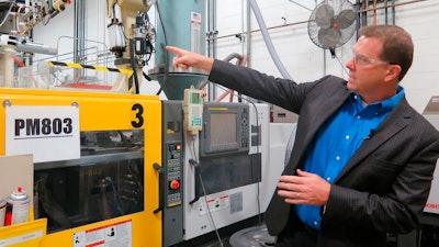 In this Wednesday, Sept. 12, 2018, photo, Paul Buzzell points to a machine used to make the levels that Johnson Level and Tool manufactures, in Mequon, Wis. But about half the levels the company sells are imported from China and tariff increases on those products could cost the business an estimated $3.7 million annually, Buzzell said.