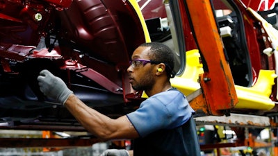 In this Sept. 27, 2018, file photo a line technician works on assembling a redesigned Nissan Altima sedan at its Nissan Canton Vehicle Assembly Plant in Canton, Miss. On Monday, Oct. 1, the Institute for Supply Management, a trade group of purchasing managers, issues its index of manufacturing activity for September.