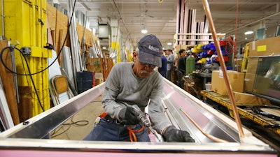 In this Thursday, Oct. 18, 2018, photo Luis Ramos works at the Howard McCray's commercial refrigeration manufacturing facility in Philadelphia. The experience Christopher Scott, president of Howard McCray, has had suggests that the impact of the tariffs is still playing out. Though has absorbed the higher costs for now, he hopes to eventually pass some on to his customers. First, though, he wants to see how his larger competitors handle the higher costs. “Little Howard McCray can’t go out and raise prices 10 percent and lose all the market share that we’ve worked so hard to gain,” Scott said.