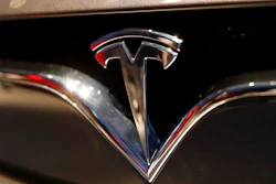 This Oct. 3, 2018, file photo shows a Tesla emblem at the Auto show in Paris. Shares of Tesla Inc. soared Tuesday, Oct. 23, a day ahead of the company’s third-quarter earnings release.