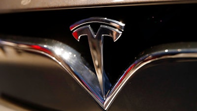 This Oct. 3, 2018, file photo shows a Tesla emblem at the Auto show in Paris. Shares of Tesla Inc. soared Tuesday, Oct. 23, a day ahead of the company’s third-quarter earnings release.