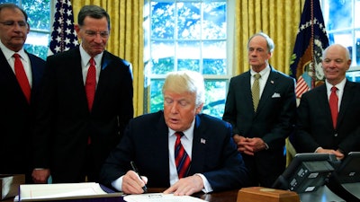 President Donald Trump signs the 'America's Water Infrastructure Act of 2018' into law during a ceremony in the Oval Office at the White House in Washington, Tuesday, Oct. 23, 2018.