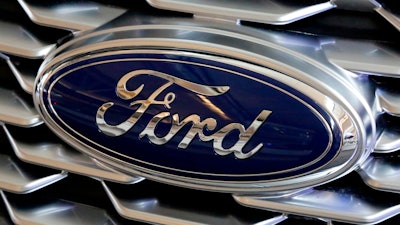 This Feb. 15, 2018, file photo shows a Ford logo on the grill of a car on display at the Pittsburgh Auto Show. Ford is recalling nearly 1.3 million Focus compact cars in the U.S. because a fuel system problem can cause the engines to stall without warning.