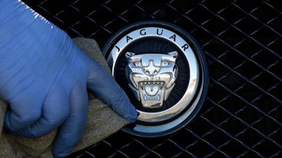 In this file photo taken on Wednesday, Sept. 28, 2016, a worker polishes a Jaguar logo on a car at a Jaguar dealer in London. Jaguar Land Rover is opening a new US$1.6 billion plant for the luxury car maker in Slovakia, its first on the continental Europe. The U.K.-based company, which is owned by India's Tata Motors, has built the plant near the city of Nitra, about 100 kilometers (65 miles) west of the capital, Bratislava, that should initially produce 150,000 cars a year which could later increase to up to 300,000.