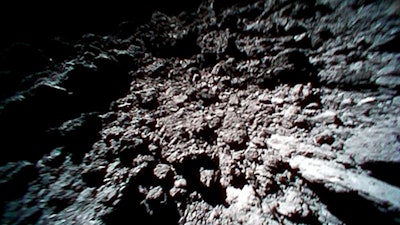 This Sept. 23, 2018 file image captured by Rover-1B, and provided by the Japan Aerospace Exploration Agency (JAXA) shows the surface of asteroid Ryugu. Japan’s space agency is delaying a spacecraft touchdown on an asteroid as scientists need more time to find a safe landing site on the extremely rocky surface.