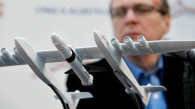 In this Dec. 13, 2011, file photo Microsoft co-founder Paul Allen looks across at a model of a giant airplane and spaceship he plans on building, during a news conference about the plane in Seattle. Prior to his death on Monday, Oct. 15, 2018, Allen invested large sums in technology ventures, research projects and philanthropies, some of them eclectic and highly speculative. Outside of bland assurances from his investment company, no one seems quite sure what happens now.
