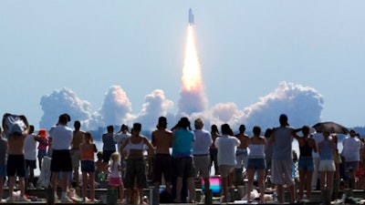 Crowds watch as the space shuttle Discovery lifts off from Kennedy Space Center in Cape Canaveral, Fla.