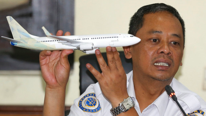 National Transportation Safety Committee investigator Nurcahyo Utomo holds a model of an airplane during a press conference on the committee's preliminary findings on their investigation on the crash of Lion Air flight 610, in Jakarta, Indonesia, Wednesday, Nov. 28, 2018. Black box data collected from their crashed Boeing 737 MAX 8 show Lion Air pilots struggled to maintain control as the aircraft's automatic safety system repeatedly pushed the plane's nose down, according to a preliminary investigation into last month's disaster.