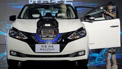 In this Aug. 27, 2018, file photo, a cameraman takes video of a Nissan Sylphy Zero Emission, the Nissan's first all-electric vehicle built in China, at the Nissan factory in Guangzhou, Guangdong province, China. More than 200 manufacturers, including Tesla, Volkswagen, BMW, Daimler, Ford, General Motors, Nissan, Mitsubishi and U.S.-listed electric vehicle start-up NIO, transmit position information and dozens of other data points to government-backed monitoring centers, The Associated Press has found. Generally, it happens without car owners' knowledge.