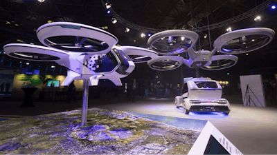 An Airbus passenger drone and Pop.Up Next, rear, a prototype designed by Audi, Airbus and Italdesign is displayed at the Amsterdam Drone Week in Amsterdam, Netherlands, Tuesday, Nov. 27, 2018. The Pop.Up Next, a two-seater vehicle, combines combines ground transportation with vertical take-off and landing.