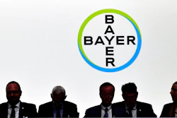 In this May 25, 2018 file photo members of the supervisory board sit in front of the company logo during the annual shareholders meeting of German chemical giant Bayer AG in Bonn, Germany. Bayer said Thursday, Nov 29, 2018 it will cut 12 000 jobs, most of them in Germany.
