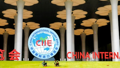 In this Oct. 26, 2018, photo, workers prepare a lawn outside the venue for the upcoming China International Import Expo in Shanghai. Facing a blizzard of trade complaints, China is throwing an 'open for business' import fair hosted by President Xi Jinping to rebrand itself as a welcoming market and positive global force.
