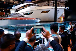 In this Nov. 6, 2018, photo, visitors gather around an Italian Yacht displayed at the China International Import Expo in Shanghai. Visitors to the vast trade fair meant to rebrand China as a welcoming import market could sip Moroccan wine, ogle Italian yachts and watch a Japanese industrial robot play ping-pong.