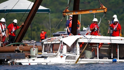 In this July 23, 2018 file photo, a duck boat that sank in Table Rock Lake in Branson, Mo., is raised after it went down the evening of July 19 after a thunderstorm generated near-hurricane strength winds, killing 17 people. A federal indictment released Thursday, Nov. 8, 2018, charges the boat's captain Kenneth Scott McKee with 17 counts of misconduct, negligence or inattention to duty by a ship's officer, resulting in death.