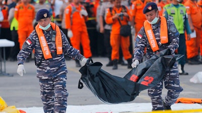 In this Thursday, Nov. 1, 2018, file photo, navy personnel carry the remains of a victim of Lion Air jet that crashed into the sea at the Tanjung Priok Port in Jakarta, Indonesia. Boeing Co. says it has issued a safety bulletin that reiterates guidelines on how pilots should respond to erroneous data from an 'angle of attack' sensor following last week's crash of a Boeing plane in Indonesia that killed 189 people.
